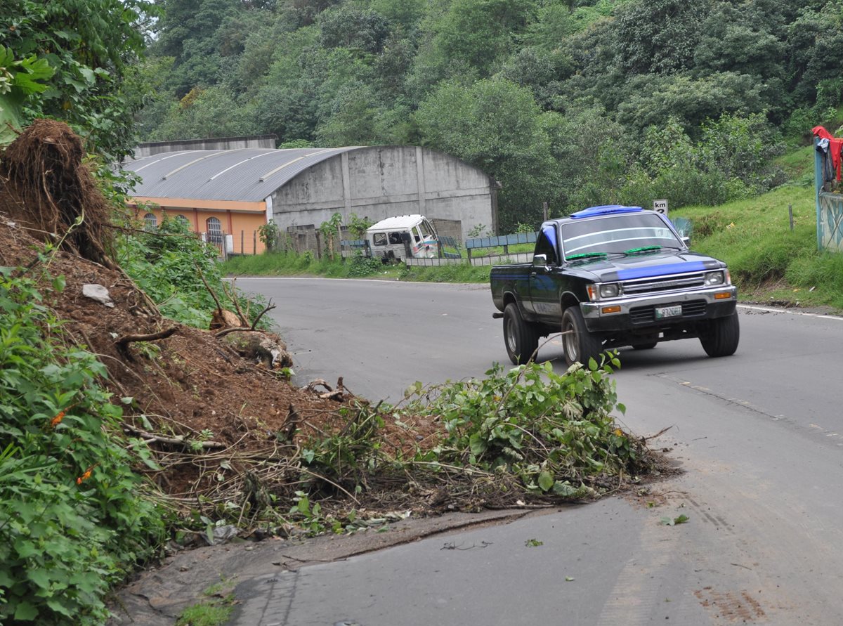 Un automovilista maniobra para esquivar el derrumbe en la ruta entre Quetzaltenango y la zona costera de San Marcos. (Foto Prensa Libre: Édgar Girón)