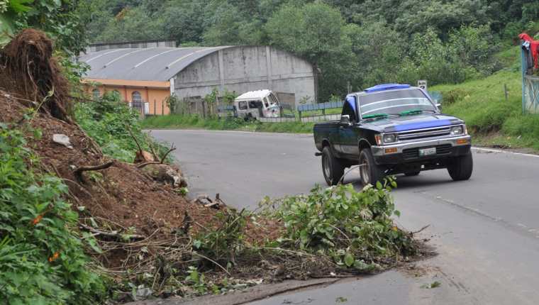 Un automovilista maniobra para esquivar el derrumbe en la ruta entre Quetzaltenango y la zona costera de San Marcos. (Foto Prensa Libre: Édgar Girón)