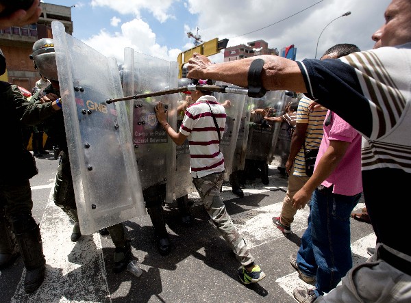 Manifestantes empujan la Guardia Nacional y demanda alimentos cerca de Caracas.(AFP).