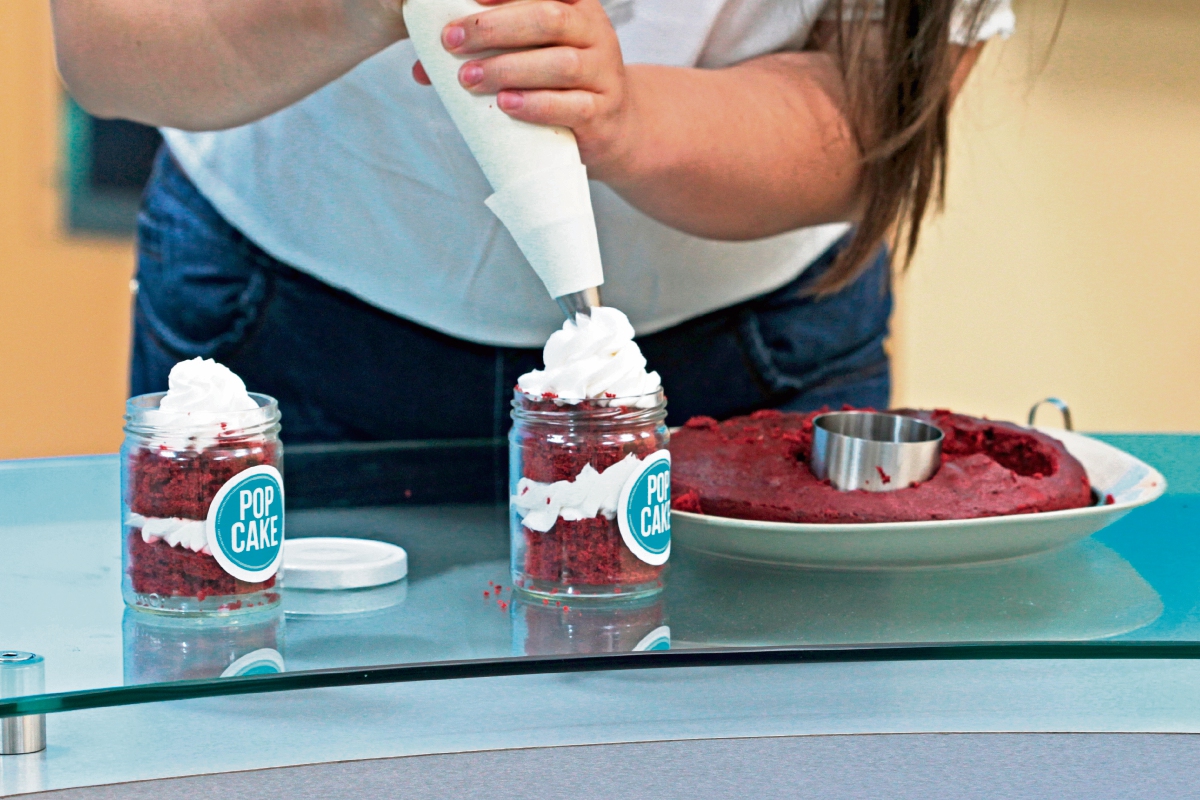 La repostera Ana Lucía García decora un pastel Red Velvet. Se pueden combinar otros sabores. (Foto Prensa Libre: Yadira Montes).