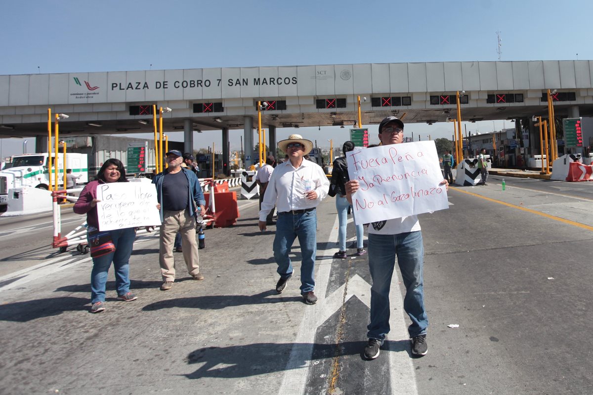 Un grupo de personas protesta contra el alza de los combutibles en el ingreso a la autopista México-Puebla. (Foto Prensa Libre: EFE).