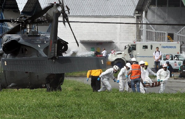 Rescatistas trasladan a una de las vítimas del accidente aéreo en Colombia. (Foto Prensa Libre: EFE).