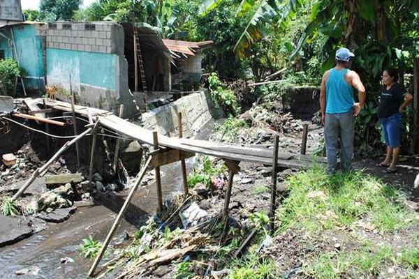 Vecinos utilizan un puente provisional para cruzar por un río que cruza por dos colonias de Río Bravo. (Foto Prensa Libre: Felipe Guzmán)<br _mce_bogus="1"/>