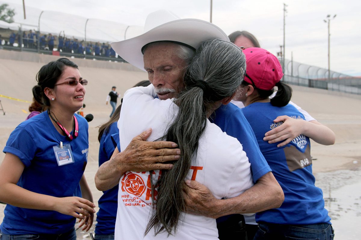 Un hombre abraza a una familiar a quien no veía durante años en al frontera sur de EE. UU. Por un lapso de 2 minutos, las autoridades estadounidenses permitieron el paso. (Foto Prensa Libre: AFP).