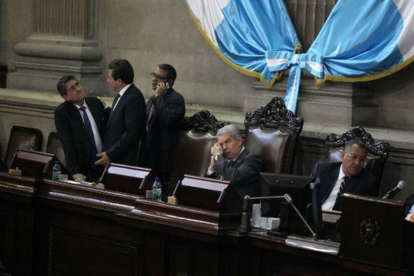 Integrantes de la Junta Directiva conversan por teléfono, en espera de diputados para comenzar la sesión. (Foto Prensa Libre: Esbin García)