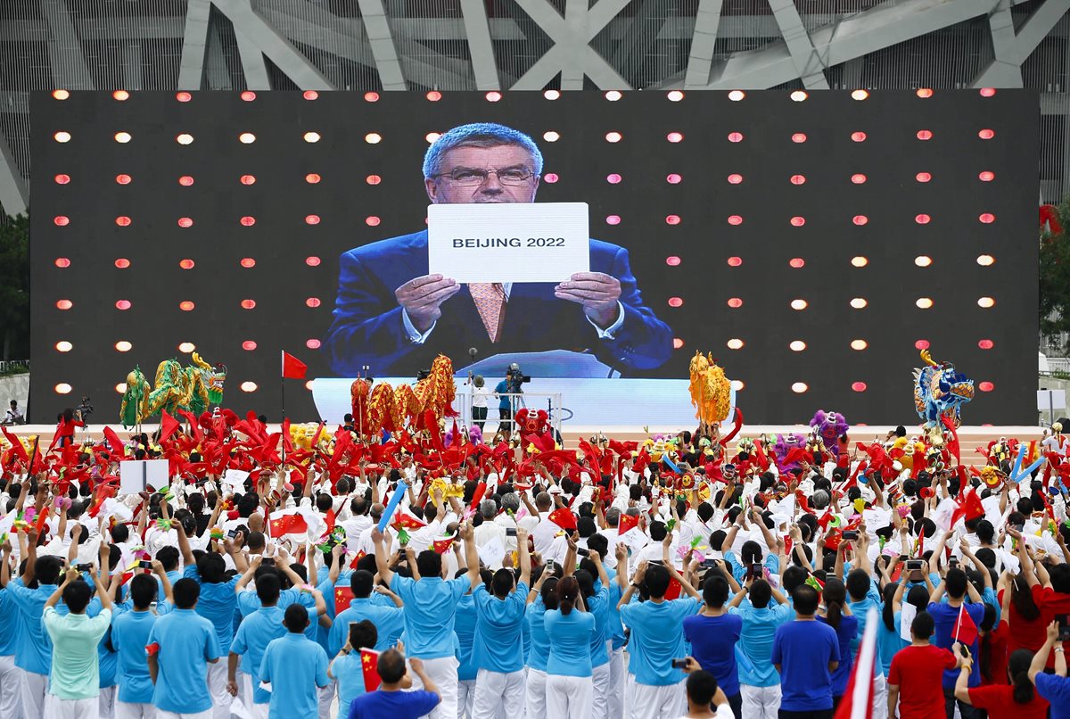 Cientos de personas festejaron la elección de Pekín como sede de los Juegos de Invierno ante el anuncio de Thomas Bach. (Foto Prensa Libre: EFE)