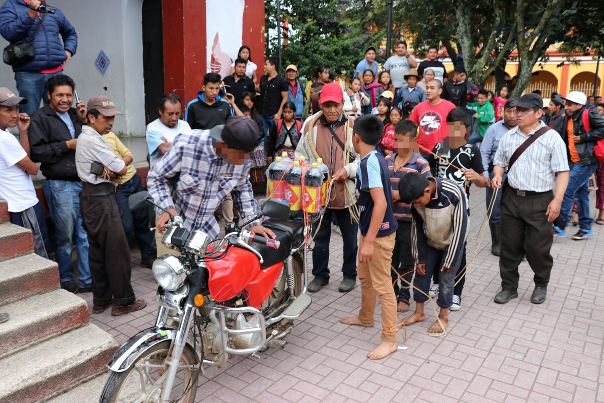 Los menores capturados empujaron una motocicleta con las bebidas que aparentemente habían robado. (Foto Prensa Libre: Héctor Cordero)