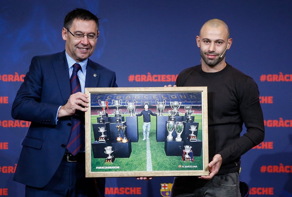 El presidente catalán José María Bartomeu entrega un cuadro con una fotografía de Mascherano con los trofeos que ganó como azulgrana. (Foto Prensa Libre: EFE)