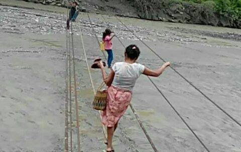 Algunas personas utilizan los cables que quedaron del puente de hamaca para cruzar el río San Vicente, en El Solís, Cabañas, Zacapa. (Foto Prensa Libre: Mario Morales)