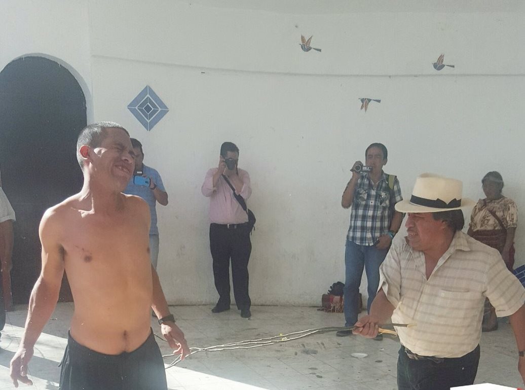 Uno de los dos señalados recibe el castigo maya por parte de la autoridad comunitaria. (Foto Prensa Libre: Knal 4)