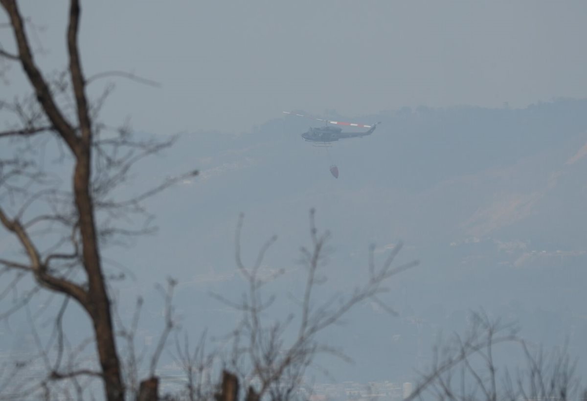 Personal de CONRED dirige al helicóptero para apoyar en el incendio.