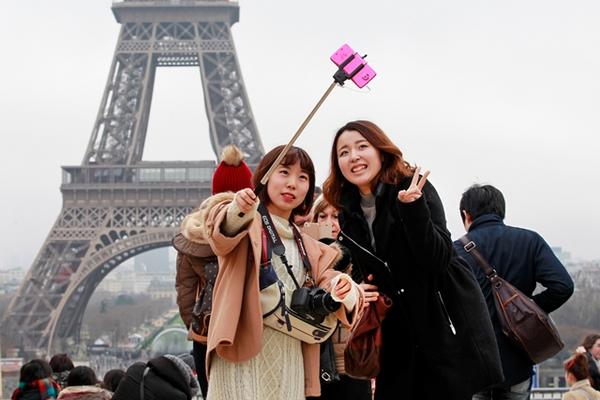 Dos turistas se toman un selfie con un bastón expandible frente a la Torre Eiffel en Paris, Francia (Foto Prensa Libre: AP).