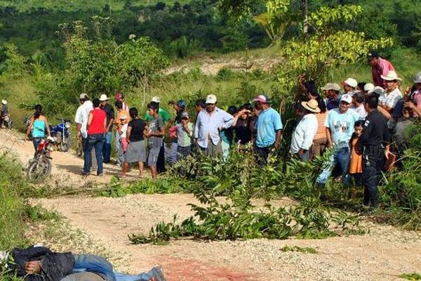Vecinos observan los cadáveres de las 7 personas. (Foto Prensa Libre: AFp)<br _mce_bogus="1"/>