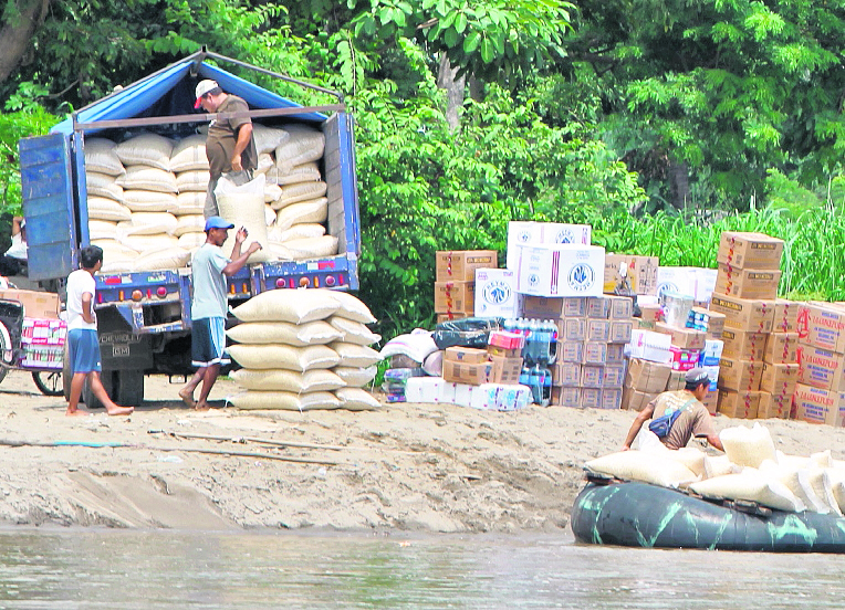 En la frontera Tecún Umán, San Marcos, dos hombres cargan un camión con maíz y articulos mexicanos de contrabando. (Foto Prensa Libre: Hemeroteca PL)