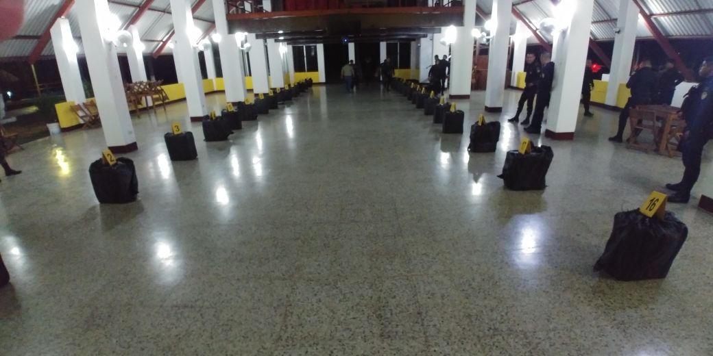 Agentes antinarcóticos de la PNC examinan los paquetes con droga localizados en aguas del Pacífico. (Foto Prensa Libre: MP)