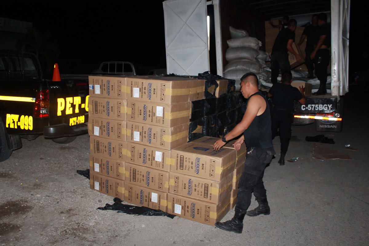 Agentes de la PNC trasladan los cigarrillos incautados a Melchor de Mencos, Petén, para incinerarlos. (Foto Prensa Libre:Walfredo Obando)