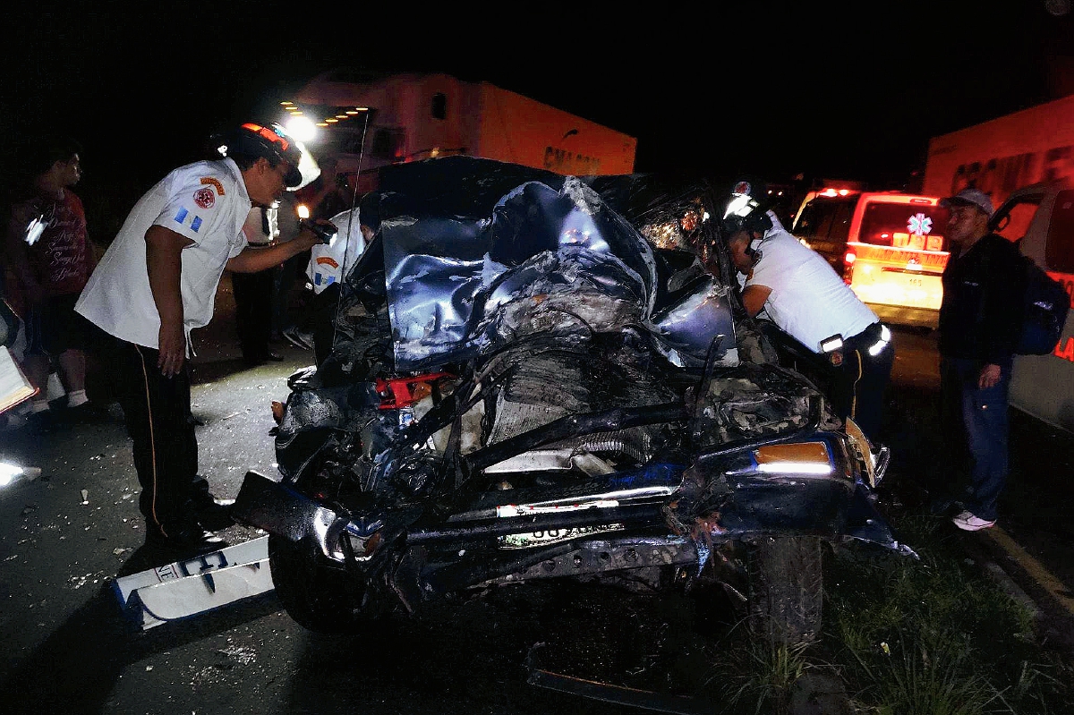 Socorristas utilizan equipo hidráulico para rescatar a víctimas de choque, en Santa Lucía Cotzumalguapa, Escuintla. (Foto Prensa Libre: Carlos Enrique Paredes)