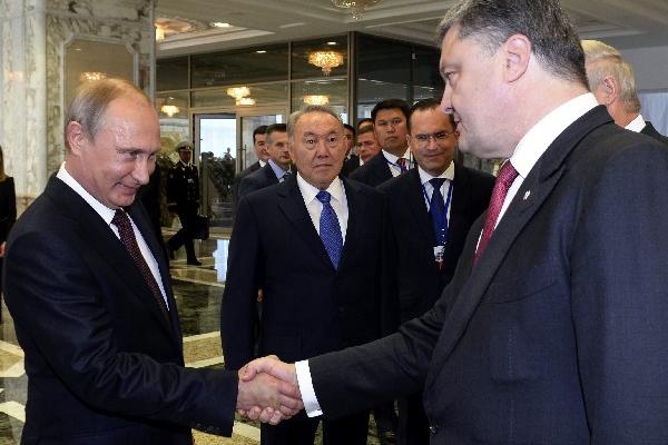 El mandatario de Ucrania, Petró Poroshenko (derecha), saluda al presidente ruso, Vladímir Putin (izquierda), a su llegada en Minsk, Bielorrusia. (Foto Prensa Libre:EFE)