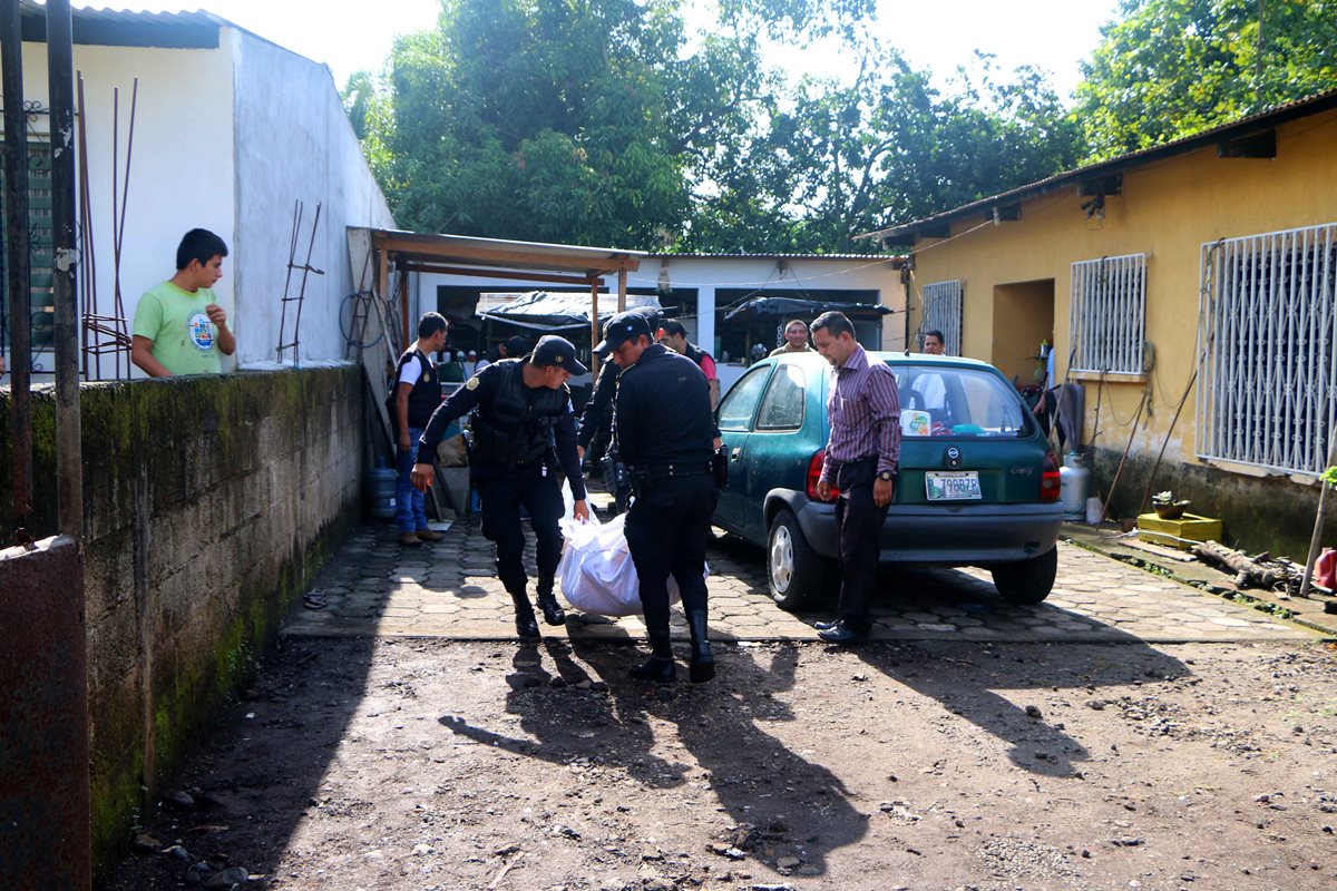Agentes de la PNC retiran el cadáver del hombre que supuestamente robaba en una vivienda de la zona 4 de Retalhuleu. (Foto Prensa Libre: Rolando Miranda)