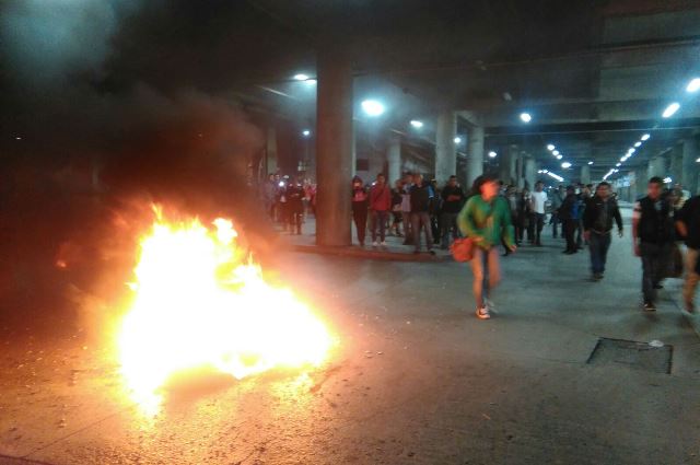 Decenas de usuarios corren debido a la quema de llantas. (Foto Prensa Libre: Gabriela López)