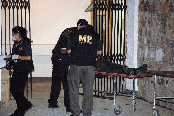 Peritos del Ministerio Público revisan cadáver de Monroy Pérez, en la morgue de Jalapa.