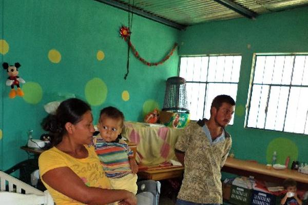 Sonia Dolores Contreras  carga a su hijo, quien padece desnutrición; a la par está su esposo.