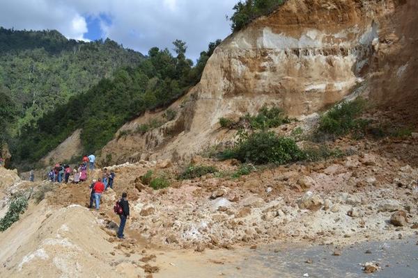 Varias personas cruzan el derrumbe para transbordar y así llegar a sus destinos. (Foto Prensa Libre: Édgar René Sáenz)<br _mce_bogus="1"/>