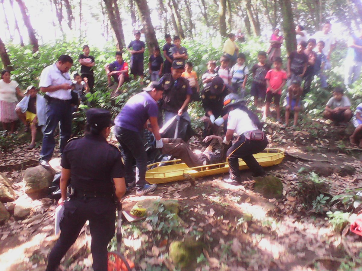Socorristas y autoridades levantan el cuerpo del octogenario hallado a las orillas del río Nimanquiej, San Antonio, Suchitepéquez. (Foto Prensa Libre: Omar Méndez).