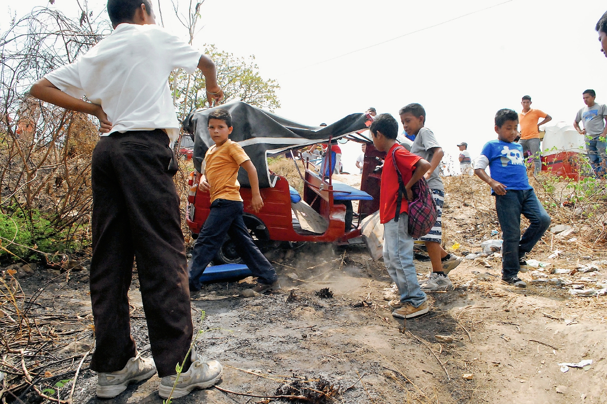 Curiosos observan el mototaxi accidentado en la carretera de Sanarate a Jalapa. (Foto Prensa Libre: Hugo Oliva)