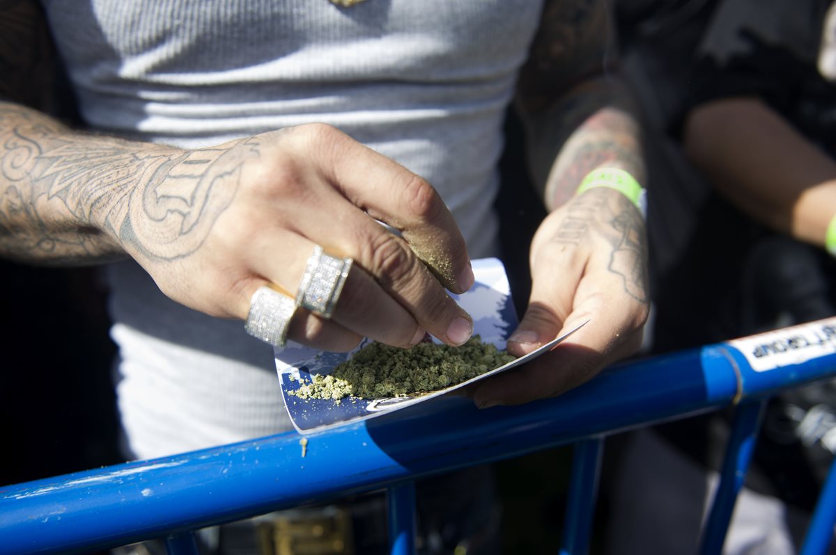 Un hombre elabora un cigarrillo de marihuana durante un festival en Denver, Colorado. (Foto Prensa Libre: AFP).
