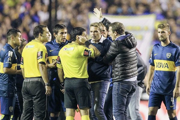El entrenador Adolfo Arruabarrena (d) de Boca Juniors habla con los árbitros luego de que lanzaran gas pimienta desde la tribuna (Foto Prensa Libre: EFE/David Fernández)