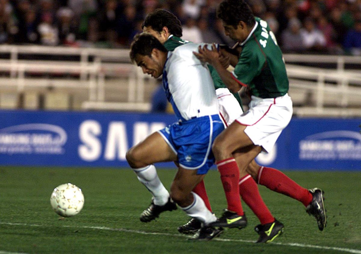 Carlos el Pescado Ruiz intenta quedarse con el balón ante la marca, en un juego contra México, en la Copa Oro del 2002. (Foto Prensa Libre: Hemeroteca PL)