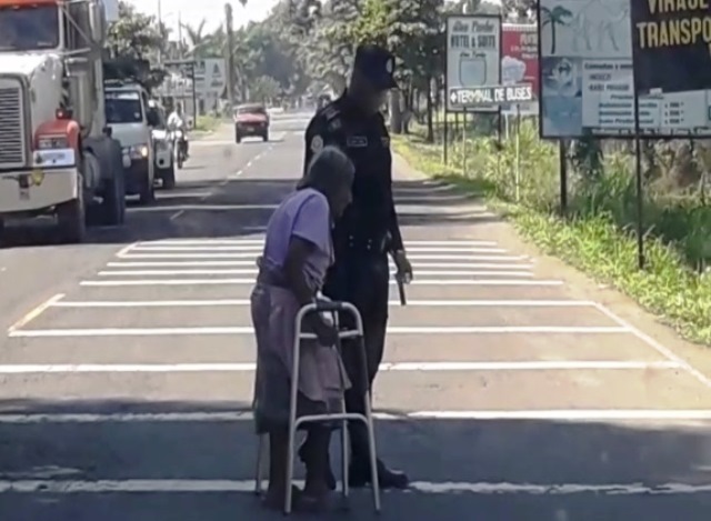 Uno de los agentes ayuda a la anciana de 77 años a cruzar la carretera, en la entrada a Tecún Umán, San Marcos. (Foto Prensa Libre: cortesía)
