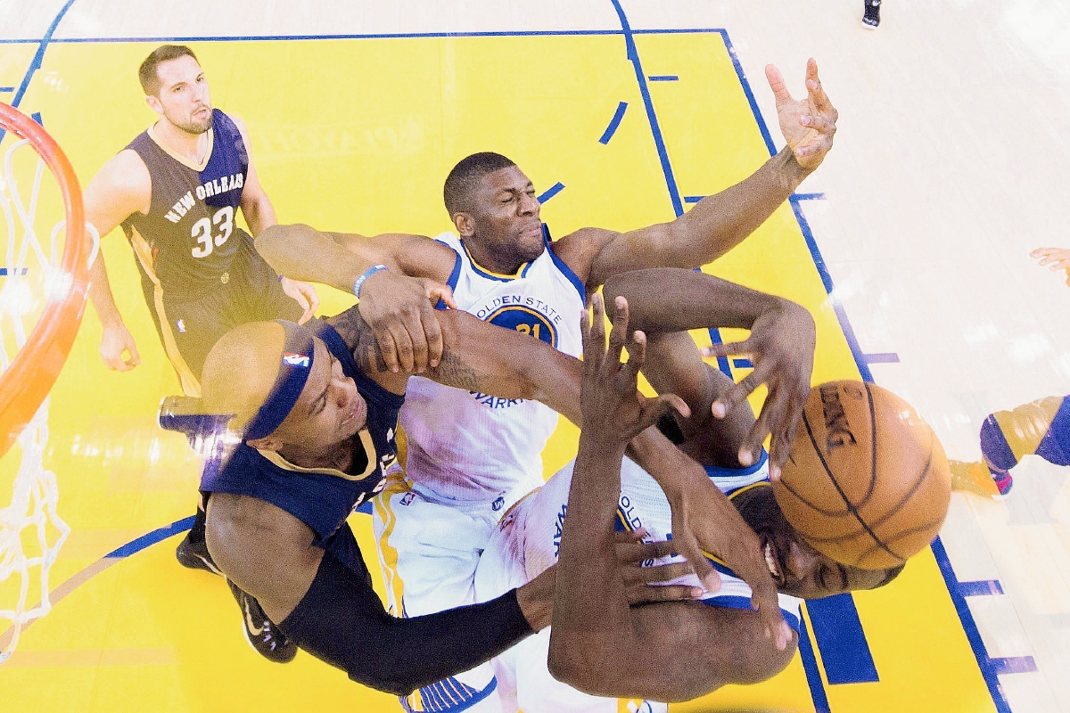Los jugadores de los Warriors Draymond Green —derecha— y Festus Ezeli —Centro— luchan por el balón con Dante Cunningham de los Pelicans. (Foto Prensa Libre: EFE).