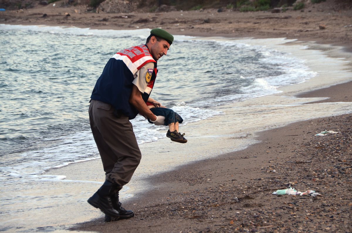Un oficial de la policía turca, rescata el cadáver del menor que fue hallado en las costas del Mediterráneo de Bodrum, Turquía, la madrugada de este miércoles. (Foto Prensa Libre: AP).