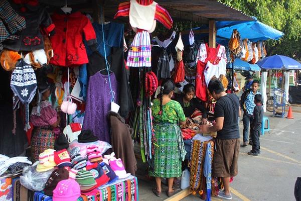 Pobladores de Chimaltenango observan en una venta trajes típicos para sus hijos. (Foto Prensa Libre: José Rosales)