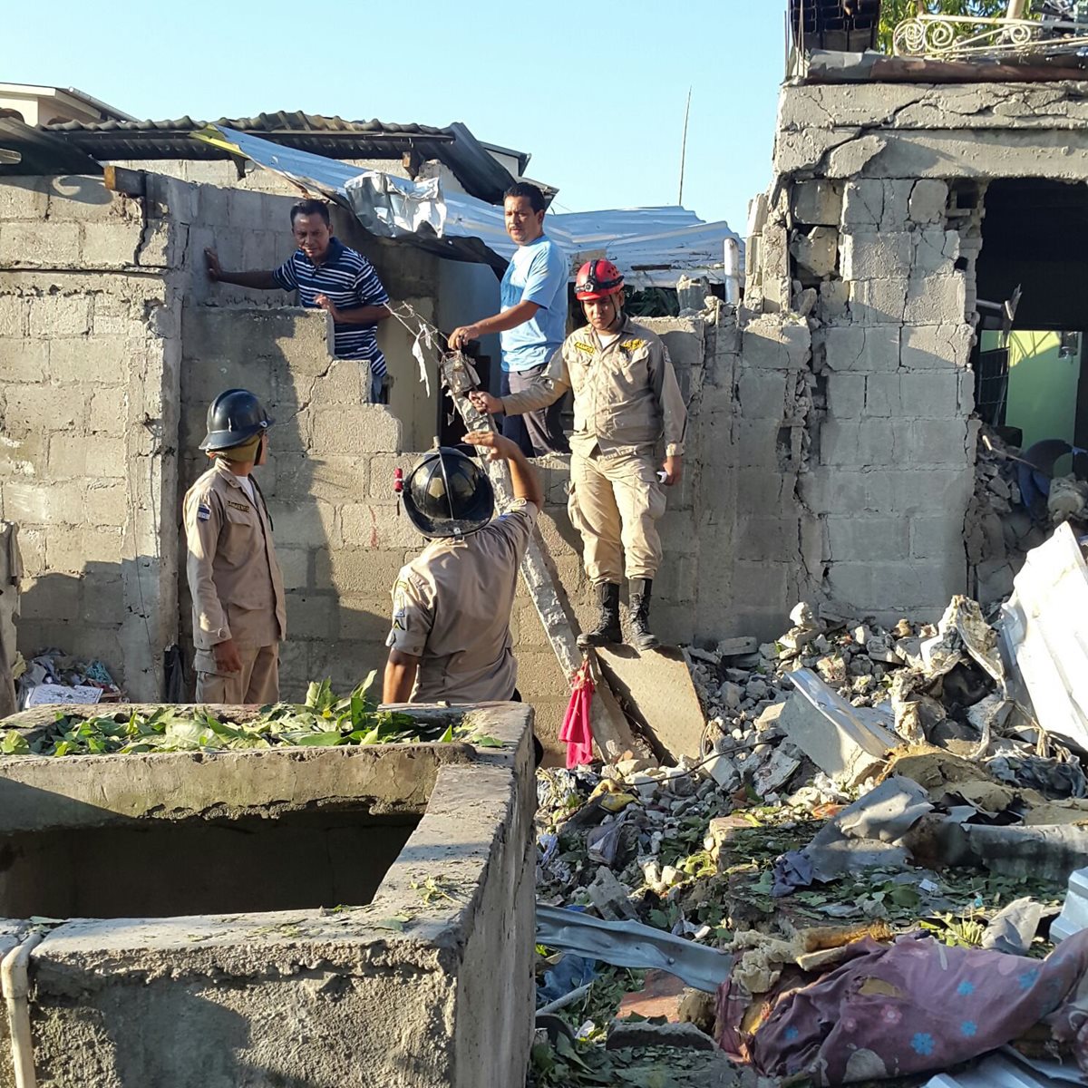 Bomberos de Honduras trabajan en medio de las viviendas afectadas por la explosión. (Foto Prensa Libre: EFE).