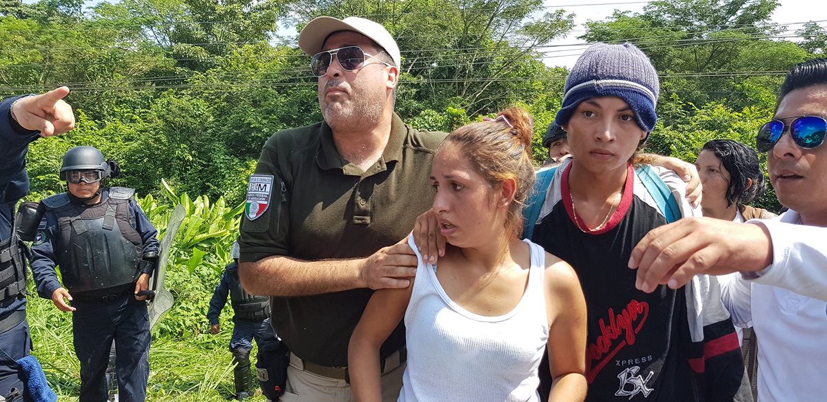 Agentes custodian a una pareja de migrantes hondureños detenidos. (Foto Prensa Libre: Cortesía agencia Xinhua)