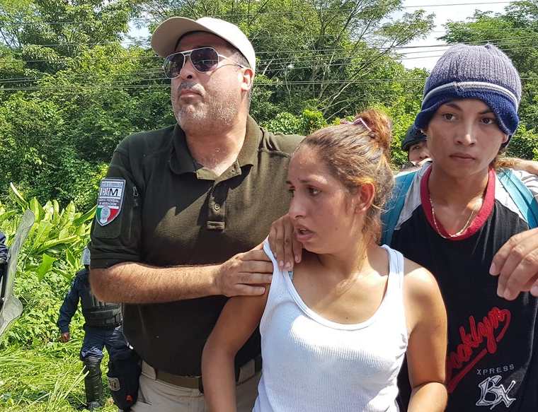 Agentes custodian a una pareja de migrantes hondureños detenidos. (Foto Prensa Libre: Cortesía agencia Xinhua)