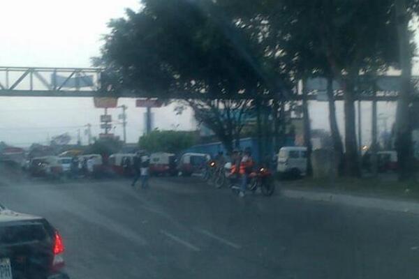 Pilotos de mototaxi y compañeros de la víctima bloquearon la ruta en la zona 6, en donde ocurrió el ataque armado. (Foto Prensa Libre: Amílcar Montejo)