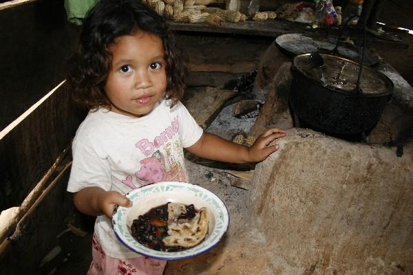 Niña de una comunidad de Los Amates, Izabal, muestra su plato de alimentos. La pobreza  y la inseguridad alimentaria afectan a gran cantidad de niños.