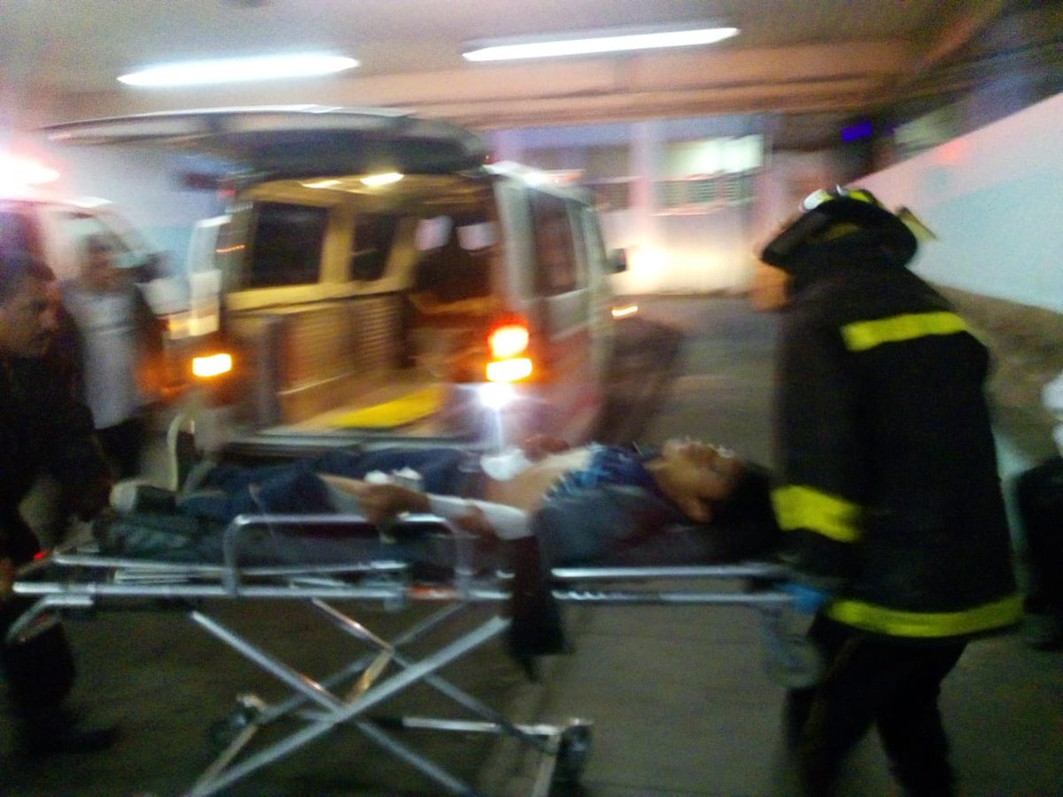 Bomberos ingresan a la emergencia del Hospital General a uno de los trabajadores baleados. (Foto Prensa Libre: Bomberos Voluntarios)