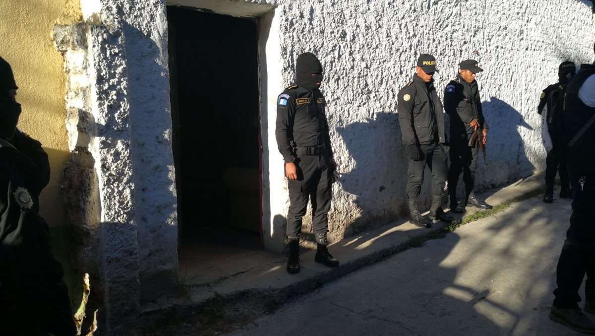 Agentes de la PNC resguardan viviendas allanadas durante operativos en varios puntos de la capital. (Foto Prensa Libre: Érick Ávila)