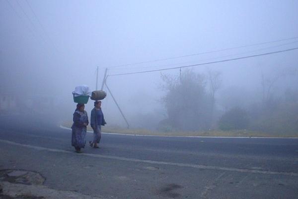 Dos mujeres caminan abrigadas por una calle de  Xelajú, debido a la baja temperatura. (Foto Prensa Libre: ARCHIVO).