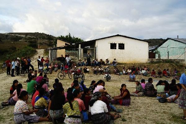 Padres de familia se reúnen frente a escuela.