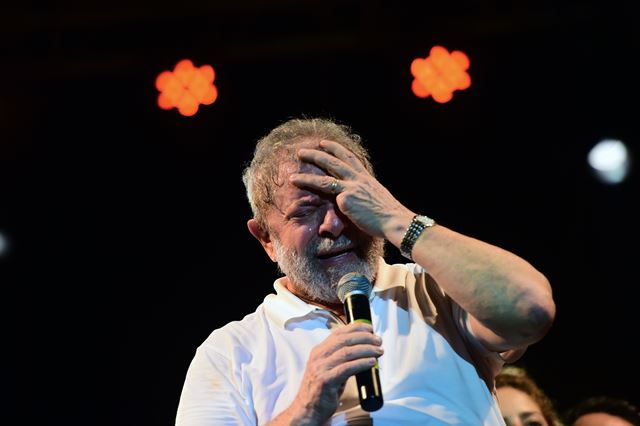 Lula da Silva se toma la cabeza durante un acto público. (Foto Prensa Libre: AFP).