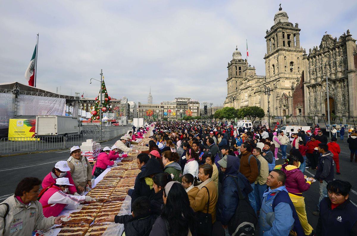 Cientos de personas en el Zócalo de la ciudad de México acuden a adquirir la tradicional Rosca de Reyes. (Foto Prensa Libre: AFP)
