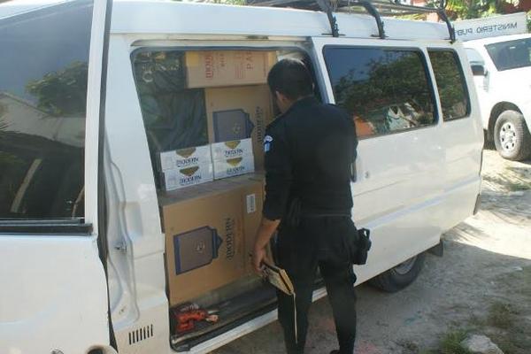 Un agente de PNC inspecciona uno de los vehículos donde se transportaban los cigarrillos. (Foto Prensa Libre: Cortesía PNC)<br _mce_bogus="1"/>