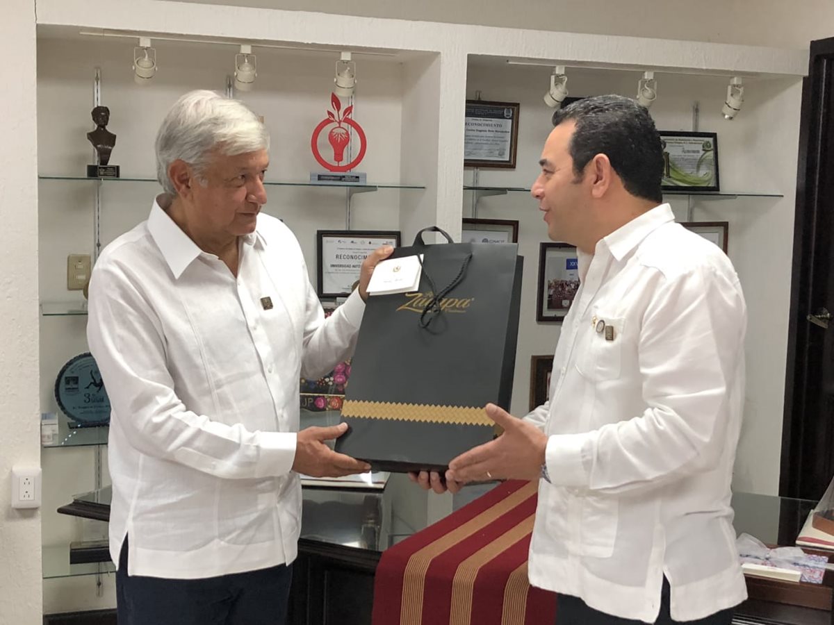 El presidente Jimmy Morales entrega una botella de ron como obsequio al mandatario electo de México, Andrés Manuel López Obrador. (Foto Prensa Libre: SCSP)