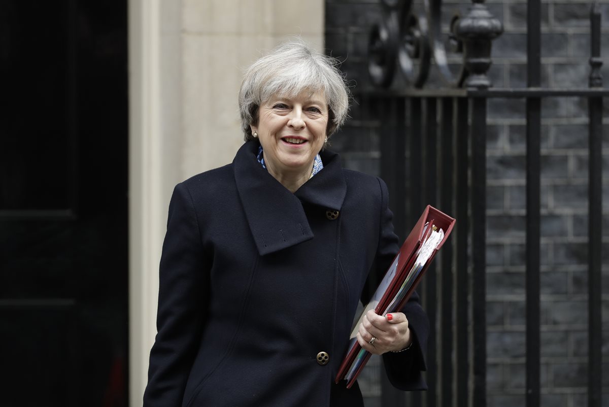 La primera ministra británica, Theresa May, sale del Parlamento tras una indagatoria. (Foto Prensa Libre: AP)